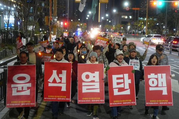  행진 선두에서 한 글자 피켓을 든 참가자들.