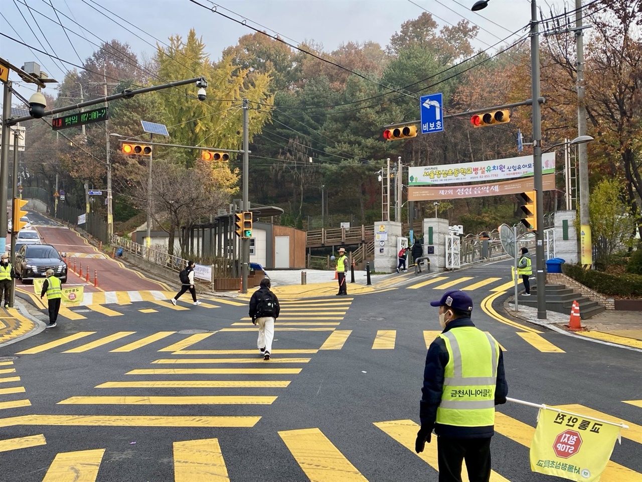  정심초등학교 앞에서 노인 일자리 참여자들이 교통안전지도를 하고 있다.,