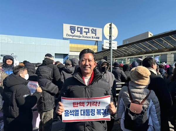  8일 동대구역에서 열린 윤석열 대통령 탄핵 반대 집회에 참석한 김장호 구미시장이 윤 대통령 복귀를 촉구하는 손피켓을 들고 있다.