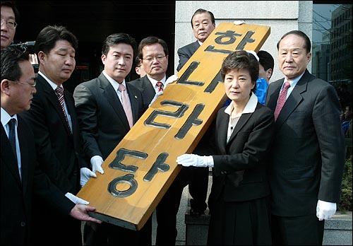  박근혜 한나라당 새대표와 당직자들이 새 당사로 이전하기 위해 구 당사에서 한나라당 현판을 떼어내고 있다.
