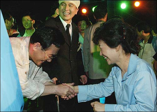 한나라당 의원들로 구성된 '극단 여의도'는 지난 2004년 4월 28일 저녁 전남 곡성 봉조리 농촌체험마을에서 '환생경제'를 창단기념으로 공연했다. 공연을 마치고 박근혜 대표가 아버지 '노가리'역을 맡은 주호영 의원과 악수하고 있다.
