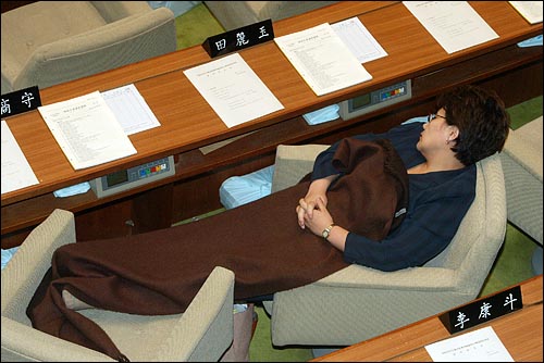 지난 2004년 12월 31일 새벽, 한나라당 의원들이 당시 열린우리당과 한나라당 원내대표의 합의를 거부하고 국회의장석을 점거한 상황에서 한나라당 전여옥 의원이 의자에 앉아 잠들어 있다.
