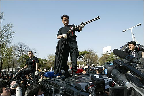 북파공작원(HID) 청년동지회 회원들이 지난 2005년 4월 서울 중학동 일본대사관 부근에서 독도침탈 시도와 역사교과서 왜곡에 항의하는 시위를 벌이던 중 오복섭 회장이 엽총을 조립하고 있다.