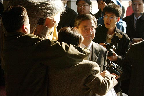 2005년 11월 16일 민주노동당원이 검찰에 출두하는 홍석현씨를 향해 구호를 외치자 포토라인에 서 있던 중앙일보 기자가 민노당원의 목을 낚아채며 제지하고 있다.