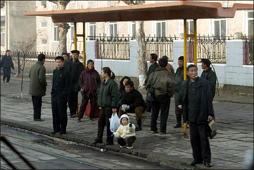  지난 2005년 11월 출근길에 나선 평양 시민들이 정류장에서 일터로 향하는 궤도전차를 기다리고 있다.
