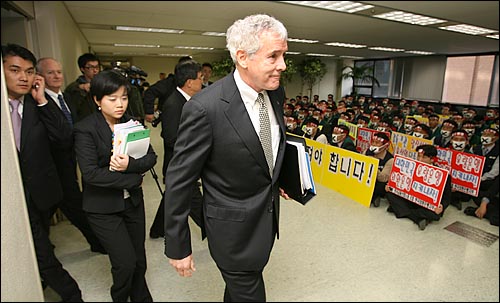 지난 2006년 3월 29일 외환은행 주주총회가 열리는 서울 을지로 외환은행 본점 4층 대강당 앞에서 은행 매각에 항의하며 침묵시위를 벌이고 있는 노조원들 앞으로 당시 외환은행 외국계 임원들이 지나가고 있다.