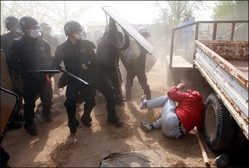2006년 5월 4일 경찰이 대추분교로 진입하는 과정에서 한 시위자를 방패로 내려찍고 있다.
