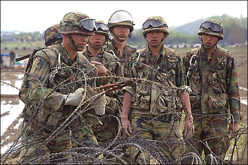 2006년 5월 7일 오후 미군기지 확장예정지인 경기도 평택 대추리 들판에 투입된 군인들이 철조망 보강작업을 하고 있다.