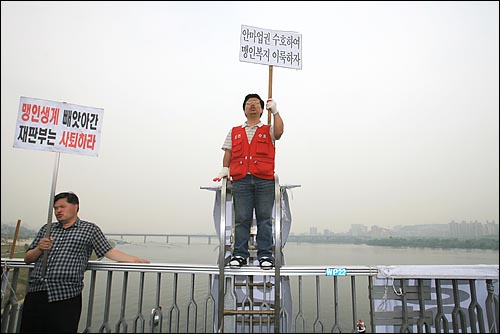 2006년 6월 8일 오전 서울 마포대교에서 시각장애인들이 헌법재판소의 시각장애인 안마사 자격 위헌 결정에 항의하며 농성을 벌이고 있다.
