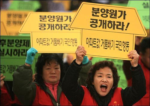지난 2006년 11월 25일 서울 세종로네거리에서 열린 '아파트값 거품빼기 국민행동 1차 시민대회'에서 한 참석자가 '분양원가 공개하라'는 팻말을 들고 있다.