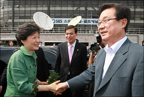 한나라당 대선후보 경선중인 지난해 7월 20일 박근혜 후보가 장애인위원회 전진대회에 참석한뒤 차에 타기에 앞서 강재섭 대표와 악수하고 있다. 